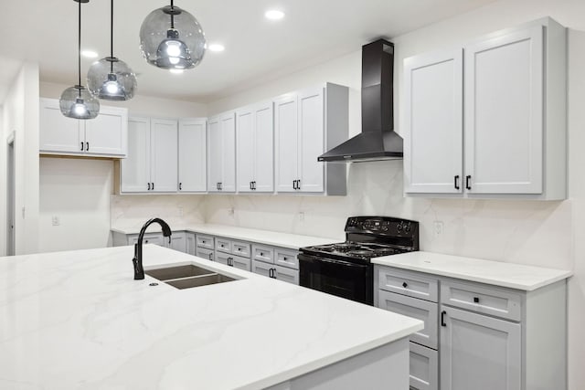 kitchen with sink, hanging light fixtures, light stone counters, black electric range, and wall chimney exhaust hood