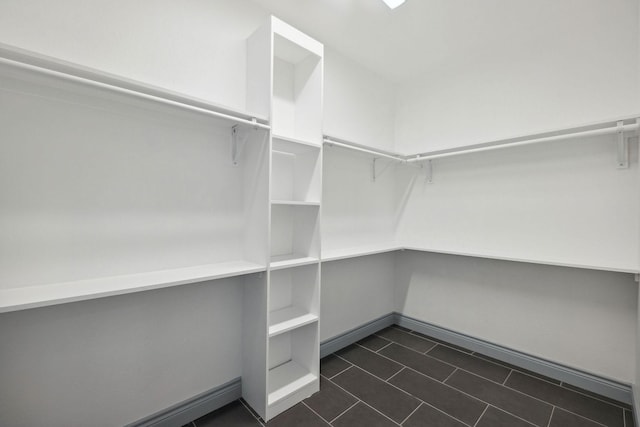 spacious closet featuring dark tile patterned flooring