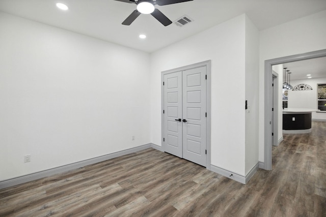 unfurnished bedroom featuring ceiling fan and dark hardwood / wood-style flooring