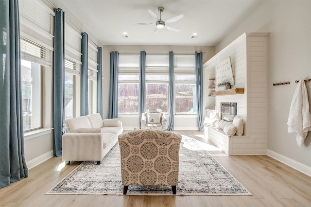 living area with ceiling fan and light hardwood / wood-style floors