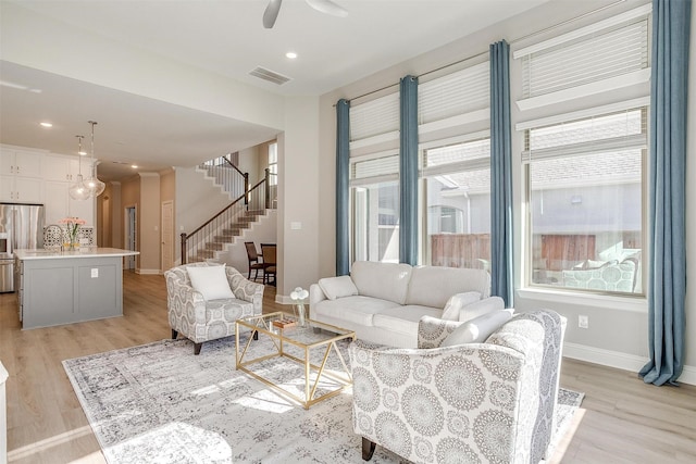 living room featuring ceiling fan and light wood-type flooring