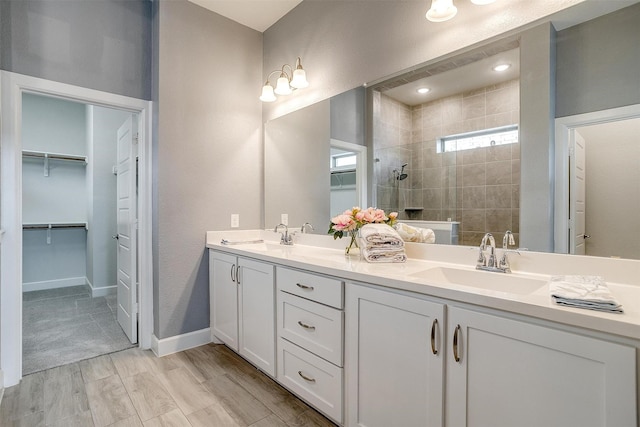 bathroom featuring a tile shower, hardwood / wood-style floors, and vanity