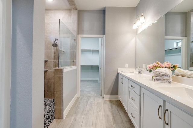 bathroom with a tile shower, vanity, and hardwood / wood-style flooring