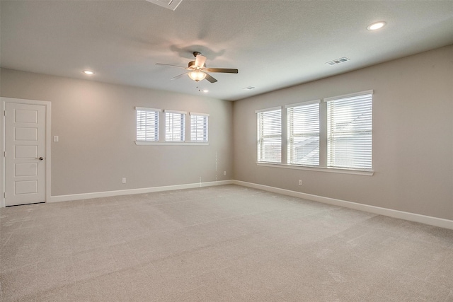 empty room with light carpet, a textured ceiling, and ceiling fan