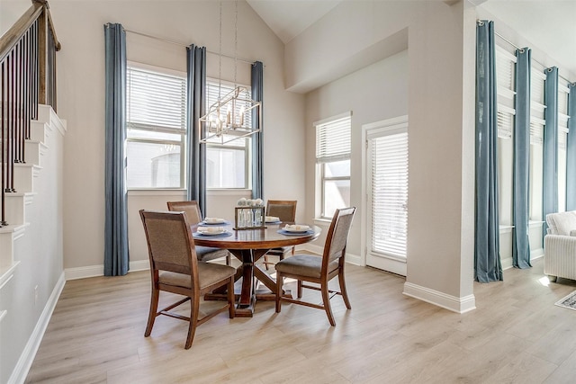 dining area featuring light hardwood / wood-style flooring, a healthy amount of sunlight, and an inviting chandelier