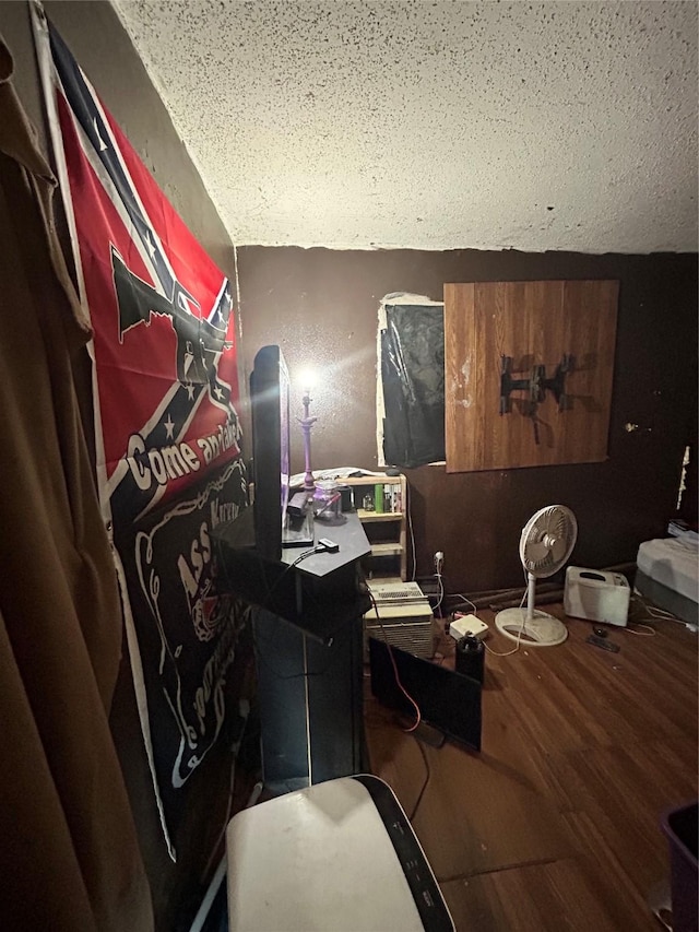 miscellaneous room featuring a textured ceiling, hardwood / wood-style flooring, and lofted ceiling