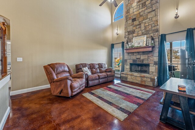 living room featuring a stone fireplace and a towering ceiling