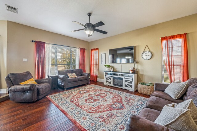 living room with ceiling fan and dark hardwood / wood-style flooring