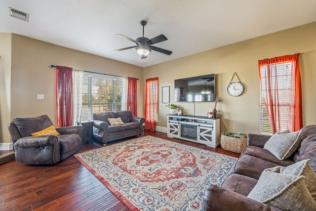 living room featuring dark wood-type flooring, plenty of natural light, and ceiling fan