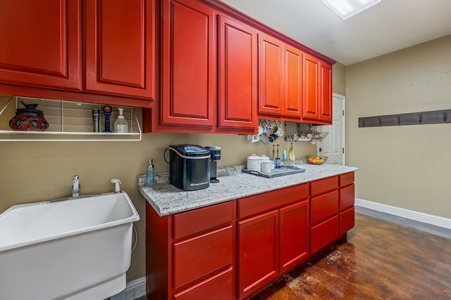 kitchen featuring light stone counters, dark hardwood / wood-style flooring, and sink