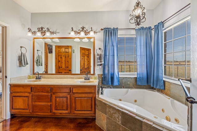 bathroom with vanity, tiled bath, and a notable chandelier