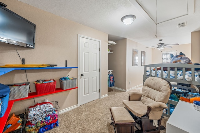 carpeted bedroom featuring a textured ceiling and ceiling fan