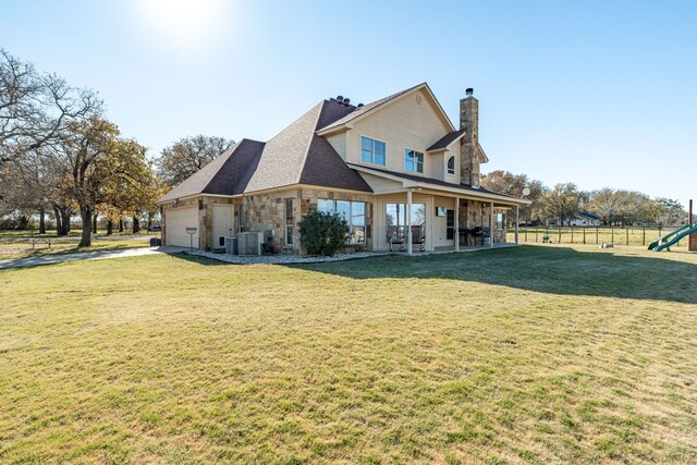 exterior space with a lawn, cooling unit, and a garage