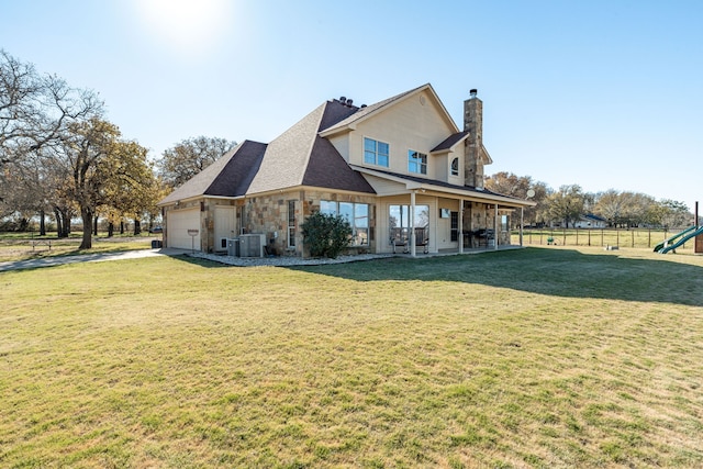 exterior space with central AC, a garage, and a yard