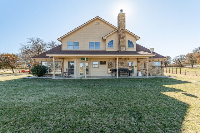 rear view of property with a patio area and a yard