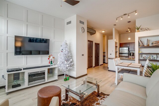 living room with ceiling fan and light hardwood / wood-style flooring