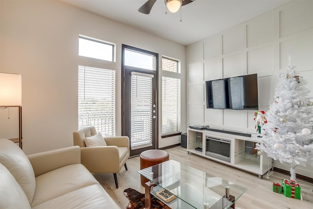 living room with ceiling fan, plenty of natural light, and light hardwood / wood-style floors