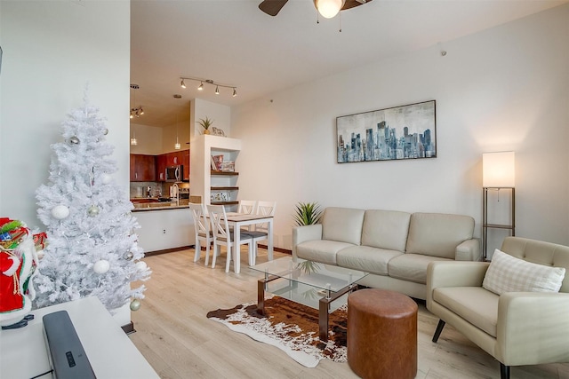 living room with ceiling fan, light hardwood / wood-style floors, and sink