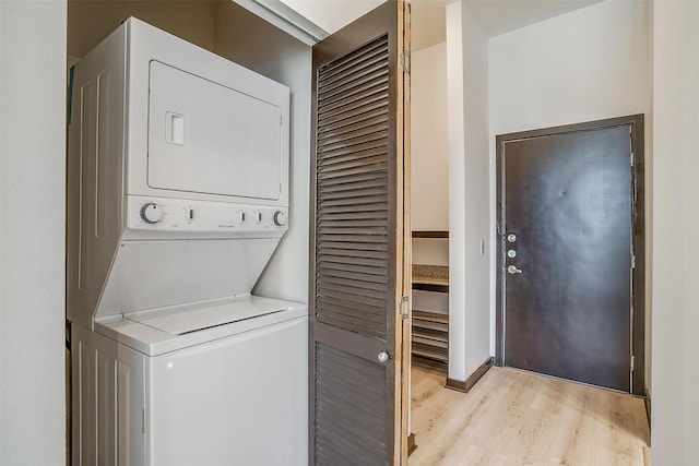 laundry room featuring light hardwood / wood-style flooring and stacked washer / dryer