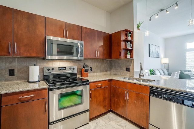 kitchen with decorative backsplash, light stone counters, sink, and appliances with stainless steel finishes