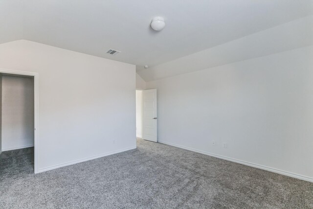 carpeted spare room featuring lofted ceiling