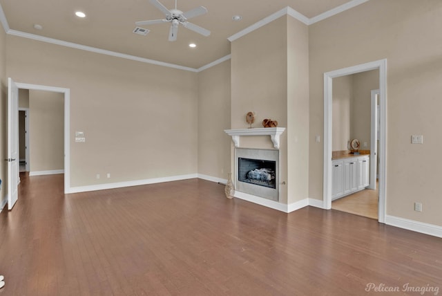 unfurnished living room with ceiling fan, wood-type flooring, and ornamental molding