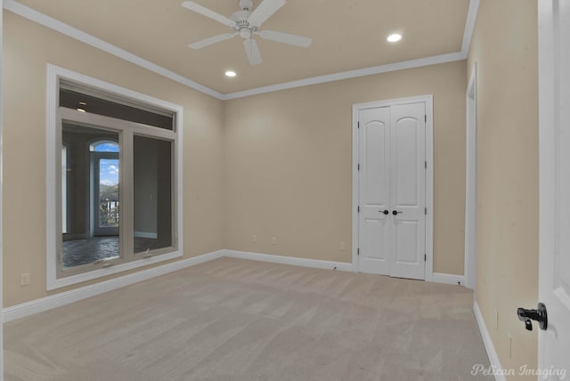 spare room with light carpet, crown molding, and ceiling fan