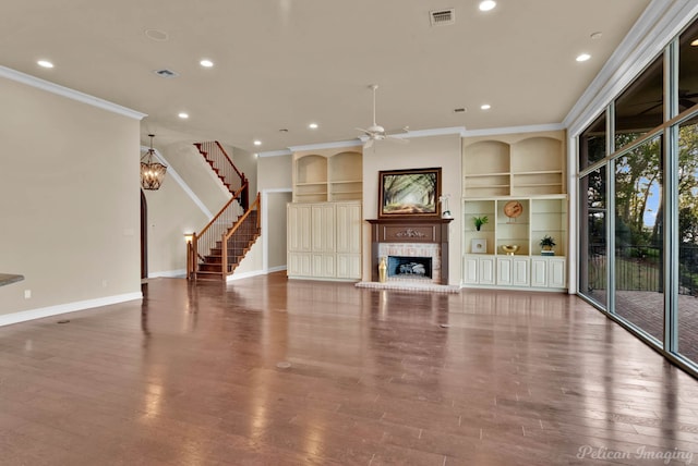 unfurnished living room featuring hardwood / wood-style flooring, ornamental molding, built in features, and ceiling fan