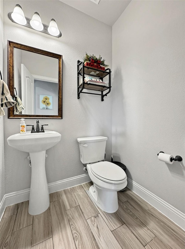 bathroom featuring toilet and wood-type flooring