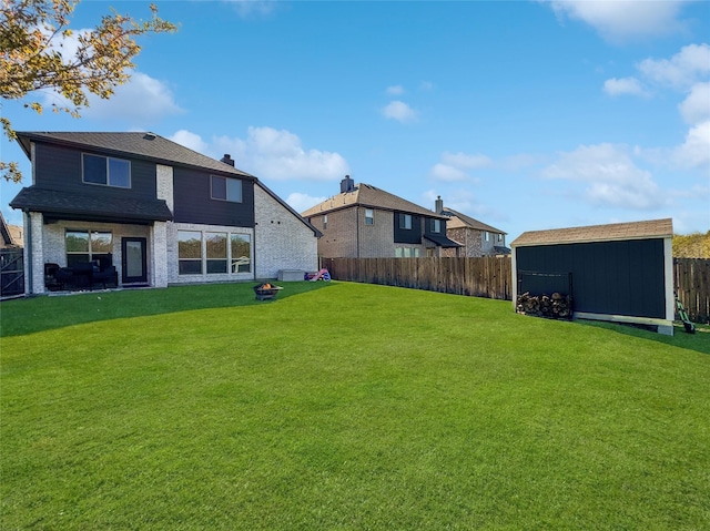 rear view of house featuring a shed and a yard