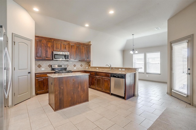 kitchen featuring sink, hanging light fixtures, a notable chandelier, a kitchen island, and appliances with stainless steel finishes