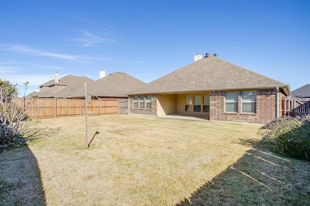 rear view of house with a patio and a lawn