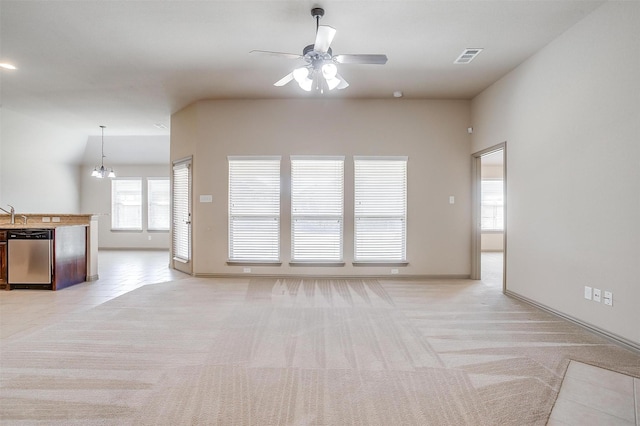 unfurnished living room with ceiling fan with notable chandelier and light colored carpet