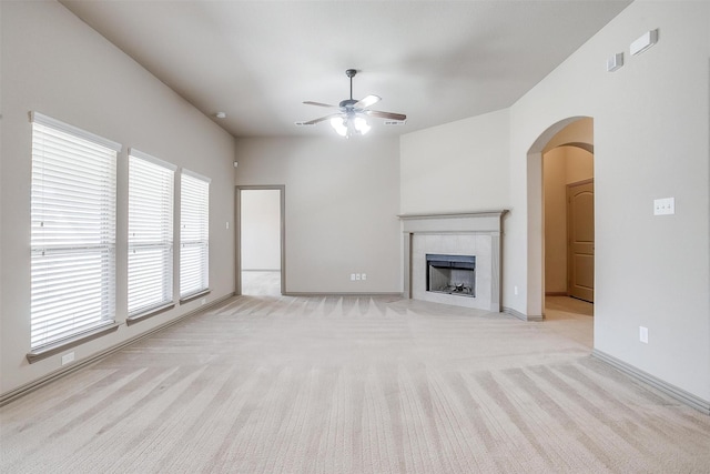 unfurnished living room featuring light carpet, a tile fireplace, and ceiling fan