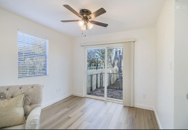 living area featuring light hardwood / wood-style floors and ceiling fan