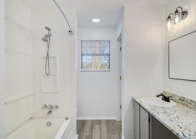 bathroom featuring bathtub / shower combination, hardwood / wood-style floors, and vanity