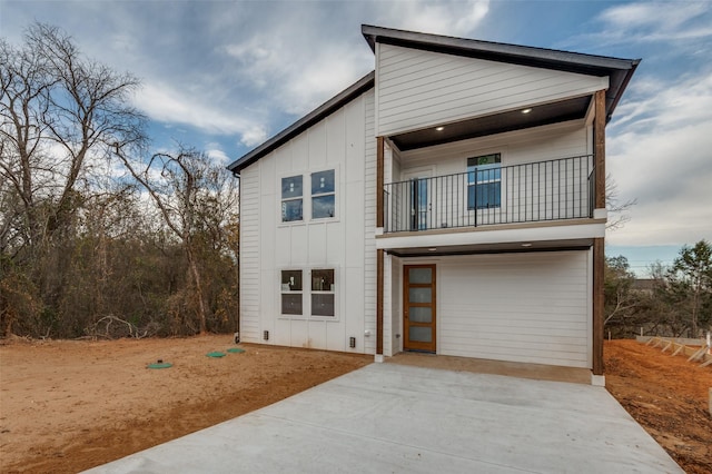 view of front of property featuring a garage and a balcony