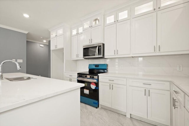 kitchen with recessed lighting, appliances with stainless steel finishes, ornamental molding, white cabinetry, and a sink