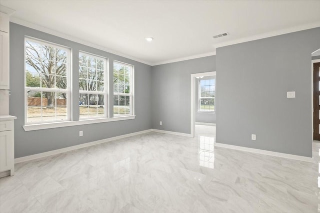 spare room with marble finish floor, baseboards, visible vents, and crown molding