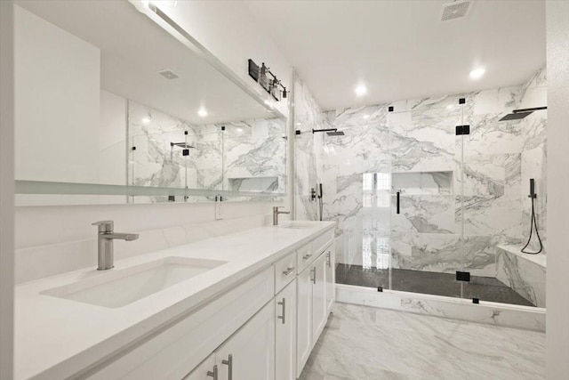 bathroom featuring marble finish floor, a marble finish shower, visible vents, and a sink