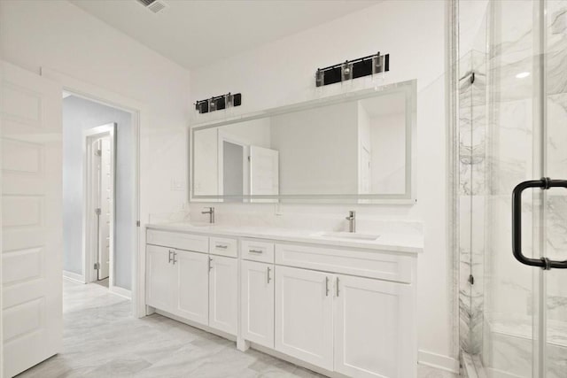 full bath with marble finish floor, a sink, a marble finish shower, and double vanity