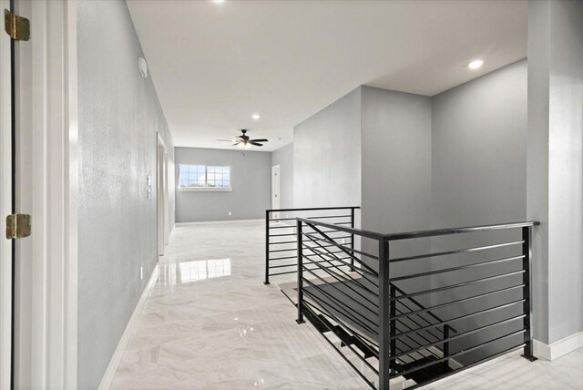 corridor with marble finish floor, recessed lighting, baseboards, and an upstairs landing