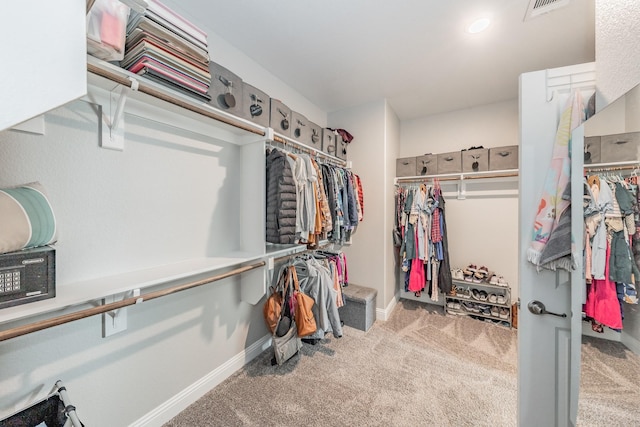 walk in closet featuring carpet flooring