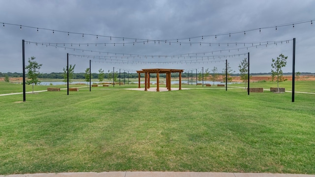 surrounding community featuring a yard, a water view, and a pergola