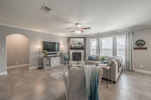 living room featuring ceiling fan, light tile patterned flooring, and ornamental molding