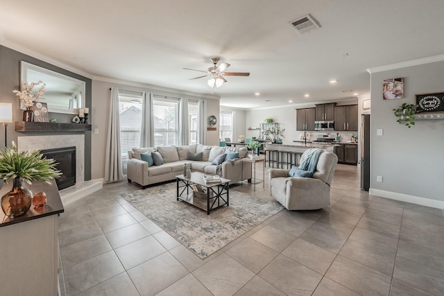 tiled living room featuring ceiling fan and crown molding