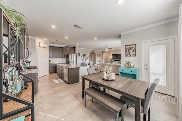 dining room featuring ceiling fan, light tile patterned floors, and crown molding