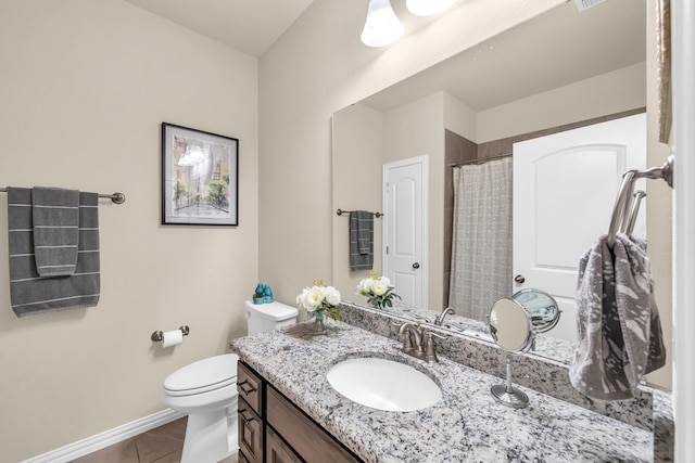 bathroom featuring tile patterned flooring, vanity, and toilet