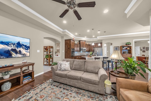 living room with ceiling fan, dark hardwood / wood-style flooring, and ornamental molding