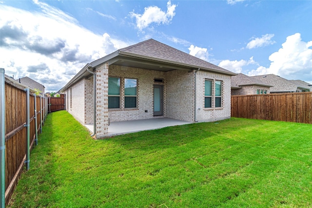 rear view of property featuring a patio area and a yard